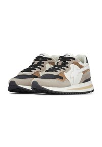 Un paio di sneaker lacciate beige, marroni, bianche e nere con suole bianche spesse e suole nere testurizzate, angolate a sinistra su sfondo bianco.