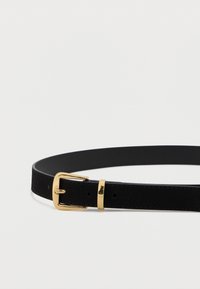 Cintura in pelle nera con una texture liscia, dotata di una fibbia in metallo dorato lucido e un accento dorato singolo vicino alla fibbia.