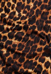 Hnedo-čierne leopardie vzory na pieskovom pozadí, hladkátextúra a mierne splývavý vzhľad.