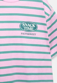 Gestreepte t-shirt in roze en groen, met een ronde hals. Gecentreerd logo leest "SNACK TIME" met "SALTY&SWEET" eronder in een contrasterende kleur.