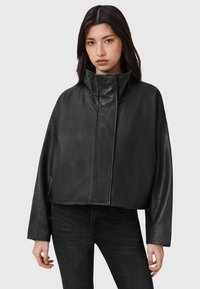 Zwarte cropped leren jas met een hoge kraag, brede mouwen en een gladde textuur, voorzien van een voorrits en minimale stiksels.