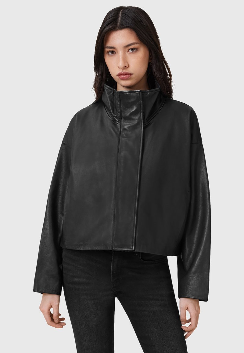 Zwarte cropped leren jas met een hoge kraag, brede mouwen en een gladde textuur, voorzien van een voorrits en minimale stiksels.