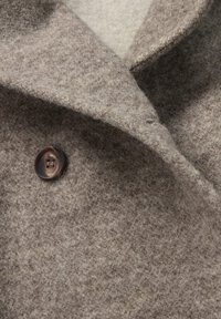 Zacht getextureerde bruine wollen jas met brede reverskraag en een enkele donkerbruine viergaatjesknop.