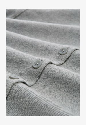 Helles graues gestricktes Sweatshirtgewebe mit horizontalen Rippstrukturen und drei runden hellgrauen Knöpfen entlang der Öffnung.