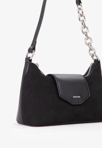 Borsa nera con frontale in pelle liscia e retro in suede texturizzato, dotata di chiusura a patta, hardware in argento e tracolla a catena.