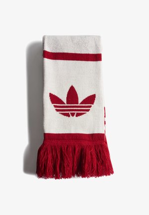 Écharpe tricotée blanche et rouge avec le logo trefoil Adidas en rouge et des franges rouges à une extrémité, pliée sur un fond blanc.