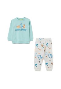 Camisa de manga larga azul claro con gráfico de "Jurassic World"; pantalones de pijama crema con estampados de dinosaurios coloridos y acentos. Tejido de algodón suave.
