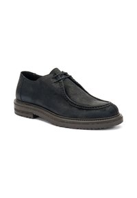 Zapato negro de ante con cordones, punta redonda y suela texturizada, exhibido sobre un fondo blanco.