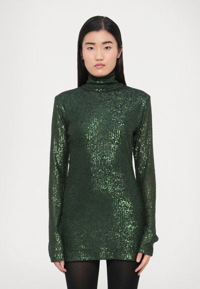 Green, sequined turtleneck sweater with long sleeves; ribbed texture; body-hugging design; extends to mid-thigh, paired with black leggings.