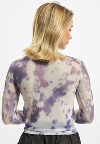 Prosojna majica dolgimi rokavi s vijoličnim in modrim tie-dye vzorcem, rebrasto teksturo ter kontrastnim modrim obrobom ob izrezu in rokavih.