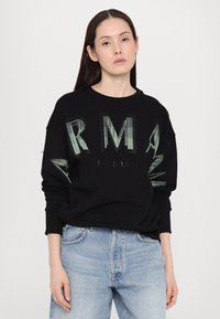 Čierna mikina s odvážnymi, zelenými pruhovanými nápismi "RM" a "EXCHANGE." S rebrovanými manžetami a okrúhlym výstrihom; voľný strih.
