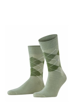 Green argyle pattern socks with ribbed cuffs, made from soft material. Features light and dark green diamonds with white accents.
