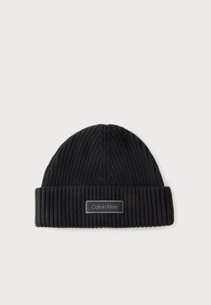 Bonnet côtelé noir avec un revers plié présentant un écusson rectangulaire du logo Calvin Klein au centre devant.