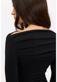 Zwarte top met lange mouwen en gedrapeerd ontwerp aan de achterkant. Heeft een brede halslijn met zachte plooien en een soepele textuur.