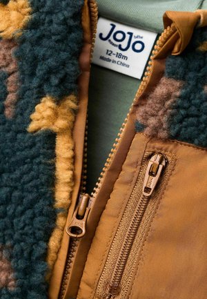 Fleecejacke mit grünem, braunem und gelbem Muster, ausgestattet mit einem braunen Reißverschluss vorne und einem Etikett, das die Größe 12-18 Monate angibt.