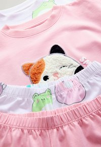 Pink cotton t-shirt with a textured animal face patch and two pairs of pajama shorts: one pink and one featuring a colorful animal print.