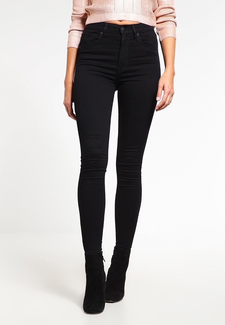 Jeans skinny de tiro alto negros con una tela suave y elástica y un ajuste elegante. Presentan un clásico diseño de cinco bolsillos y costuras sutiles.