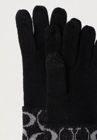 Ζευγάρι μαύρα πλεκτά γάντια με γκρι μανσέτες με σχέδια και μαύρες άκρες συμβατές με οθόνες αφής στον αντίχειρα, τον δείκτη και το μέσο δάχτυλο.