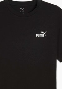 Camiseta de algodón negra con cuello redondo, mangas cortas y un pequeño logo blanco de Puma en el lado izquierdo del pecho. Textura suave.
