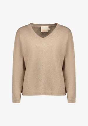 Pull en cachemire beige avec un col en V, coupe ample, manches longues et poignets côtelés. Texture douce avec un design minimaliste et étiquette de la marque visible.