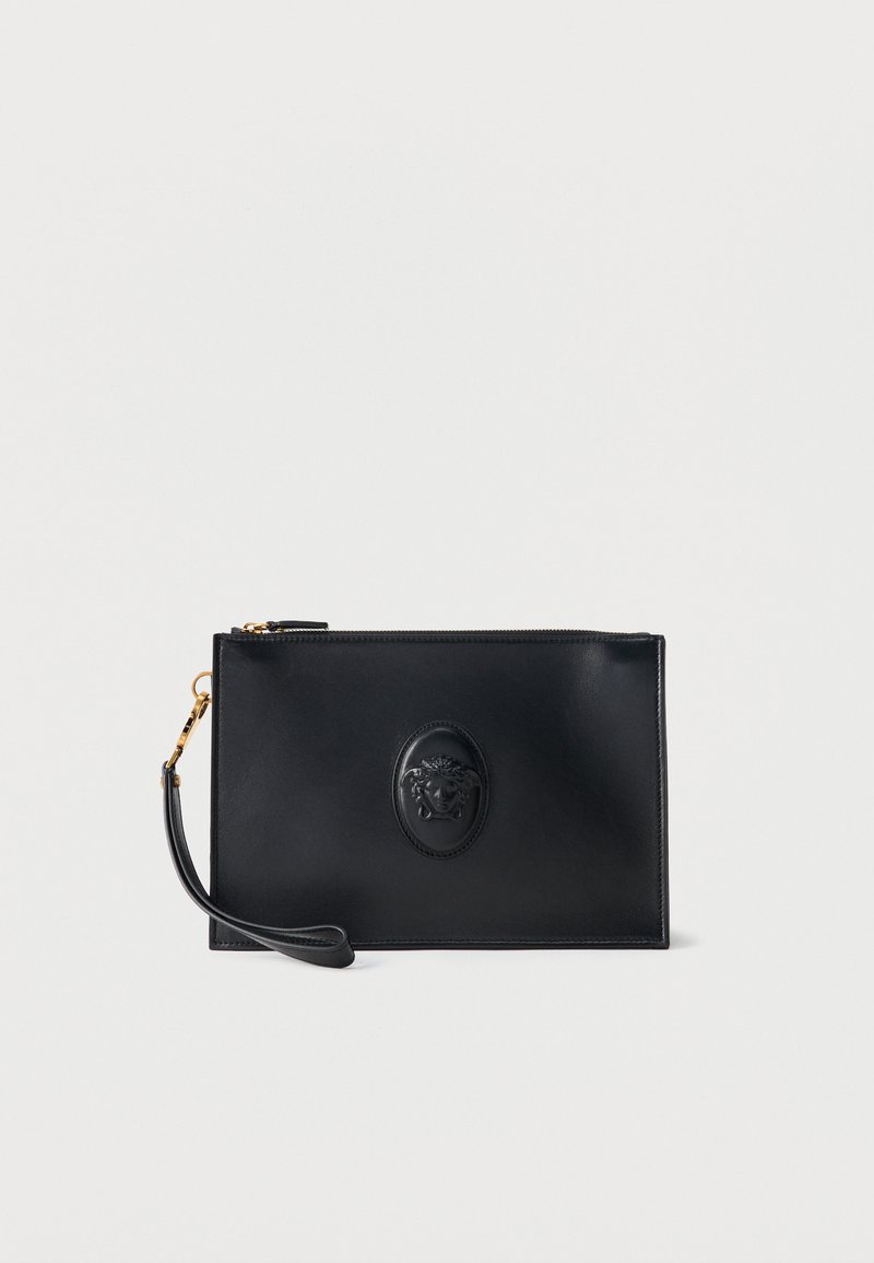 Μαύρο δερμάτινο wristlet με χρυστό φερμουάρ και κεντρικό ανάγλυφο έμβλημα Μέδουσας σε λευκό φόντο.