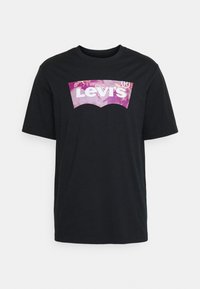 Černé tričko s krátkým rukávem vyrobené z bavlny. Na přední straně má velké obrobené logo Levi's v purpurové a bílé barvě.
