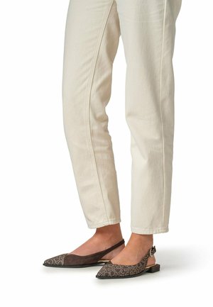 Beige slim-fit broek gedragen met bruine slingback flats met puntige neus, voorzien van een textuur en patroon, en lage vierkante hakken.