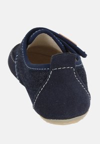 Scarpa in suede blu navy con punta rotonda, dettagli cuciti e un morbido rivestimento interno. Presenta una suola flessibile e un tallone per indossarla facilmente.