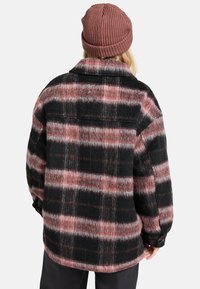 Geruite fleece jas in zwart, roze en grijs. Voorzien van een kraag, lange mouwen en een licht gebogen zoom.