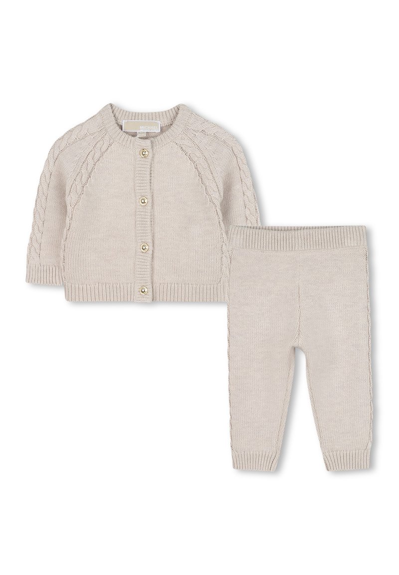 Ensemble en deux pièces tricoté en beige clair. Le cardigan présente un col rond et des accents en tricot torsadé ; le pantalon a une taille et des poignets côtelés.