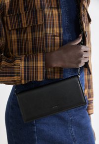 Calvin Klein GLOW CHAIN MINI BAG - Alkalmi kézitáska - black
