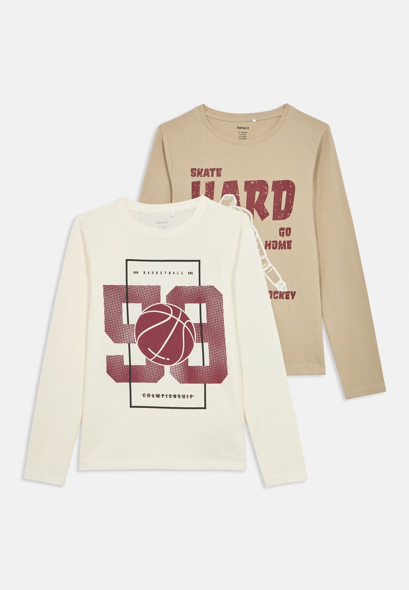 Duas camisetas de manga longa; uma em creme com um gráfico de basquetebol e texto em bordô, e outra em bege com texto em vermelho sobre skate. Tecido em mistura de algodão.