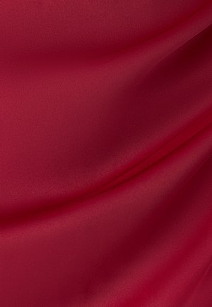 Lygus raudonas audinys su švelniais raukšlėmis ir subtilia tekstūra, sukuriančia švelnias šešėlių ir šviesos atspindžių žaismas.