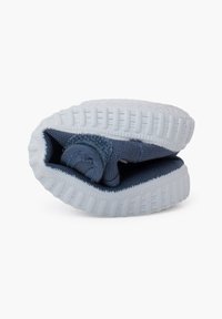Baskets en maille bleu foncé flexibles pliées pour montrer la semelle blanche texturée et l'élasticité du tissu.