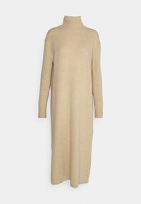 Robe-pull longue beige en maille avec col montant côtelé, manches longues et poignets côtelés, avec fentes latérales.