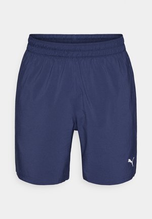 Marineblauwe sportbroek met elastische tailleband, voorzien van een klein wit Puma-logo linksonder. Lichtgewicht, gladde stof.