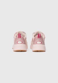 Un paio di sneakers rosa FILA con design in rete e pelle, suole in gomma e linguette rosa, viste da dietro su uno sfondo bianco.