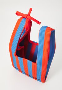 Piros és kék csíkos textil táska, erős kivitelben, tetején fűzhető záródással és téglalap alakú. Könnyű és rugalmas textúrával.