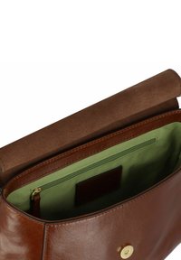 Borsa a mano in pelle marrone con una superficie liscia, foderata in tessuto verde e una patta in suede beige. Presenta una tasca con zip e dettagli in oro.