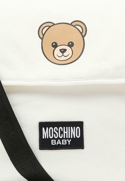 Hvidt stofpose med grafik af en brun bjørneansigt og en sort broderet "MOSCHINO BABY"-etiket i rektangulær form. Sort stropdetalje.