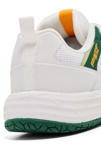 Närbild av en vit sneakers häl med grön texturerad sula, vit dragflik, mesh-ovandel och gröna och orange detaljer.