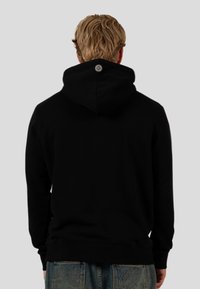 Czarna bluza z dużym kapturem, prążkowane mankiety i dół, z okrągłym logotypem z tyłu. Miękka tekstura materiału.