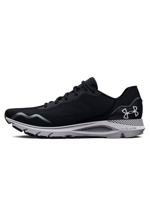 Chaussure de sport noire avec un dessus texturé, accents gris et une semelle intermédiaire blanche courbée. Caractérisée par une semelle à motif pour une meilleure adhérence.