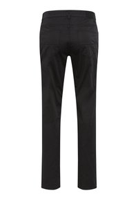 Zwarte broeken met een slim fit. Beschikt over achterzakken met subtiele stiksels en een glad, mat textuur. De tailleband heeft riemlussen.