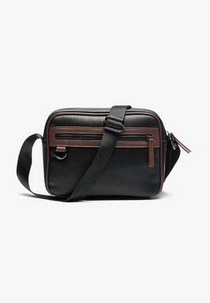 Sac bandoulière rectangulaire noir et marron avec sangle réglable, poche avant zippée et anneau en D métallique sur fond blanc.