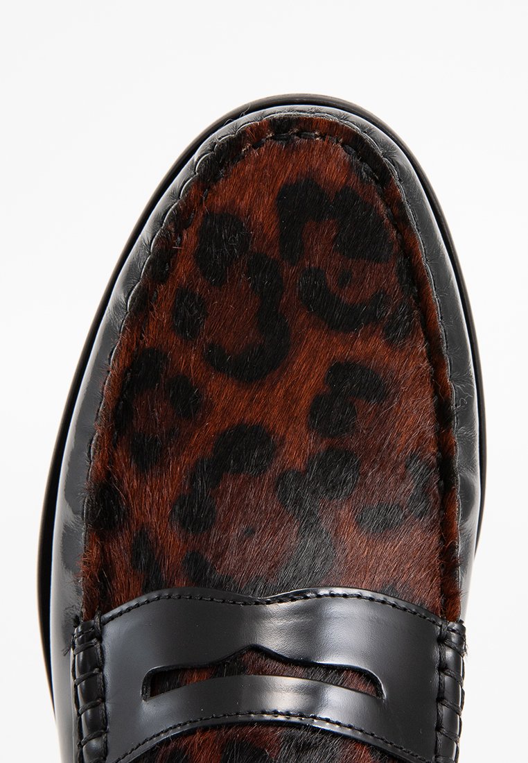 Mocassins à imprimé léopard avec texture de fourrure marron et accents en cuir noir. Présentent une sangle décorative noire et des détails de couture visibles.