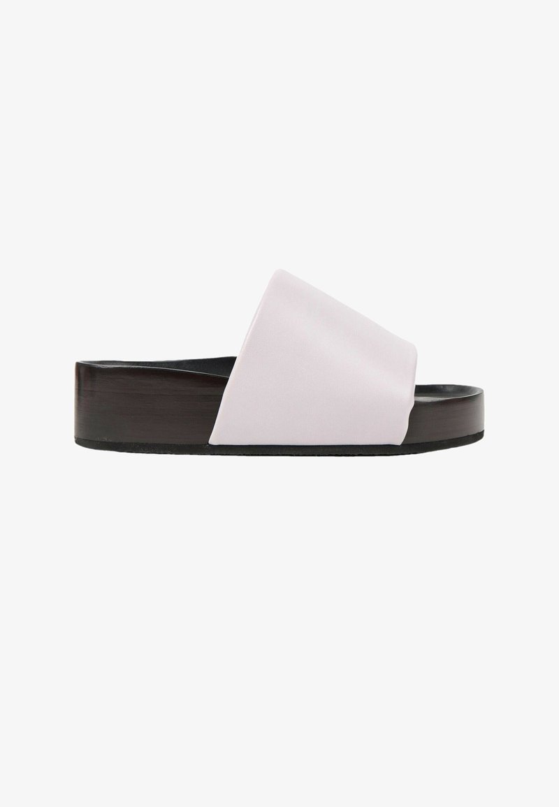 Sandale mules noire avec une large bride en tissu blanc et une semelle légèrement surélevée, vue de profil sur fond blanc uni.