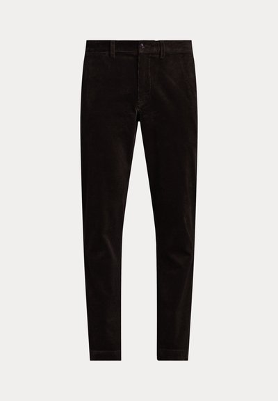 Fekete slim-fit kordbársony nadrág gombos és cipzáras záródással, övhurkokkal és egyszínű elülső résszel fehér háttéren.
