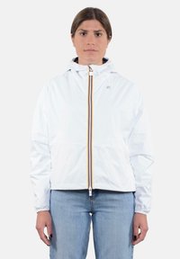 Giacca leggera bianca con cappuccio, dotata di zip frontale con dettagli arancioni e gialli, polsini elastici e un taglio casual.