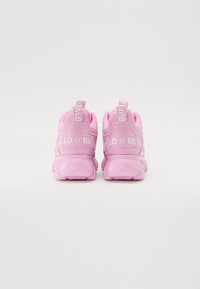 Sneakers atletiche rosa con una tomaia in tessuto testurizzato, caratterizzate da un marchio bianco sul tallone e sulla linguetta, e una suola in gomma spessa.